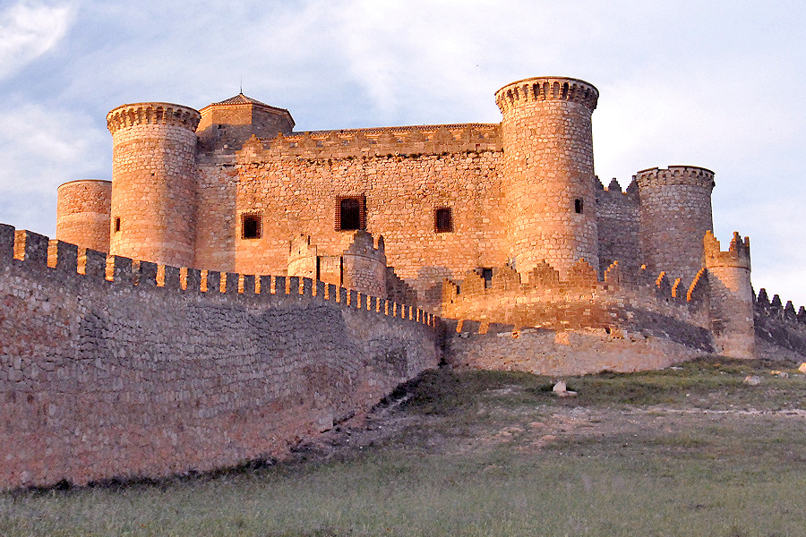 Castillo de Belmonte iluminado al atardecer durante el viaje de la Asociación de Jubilados de Pareja